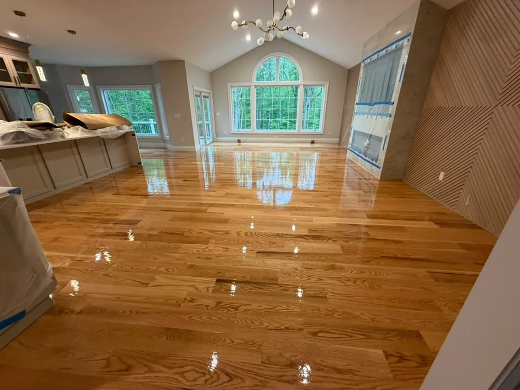Amber hardwood in high gloss in a vaulted room with an arched window