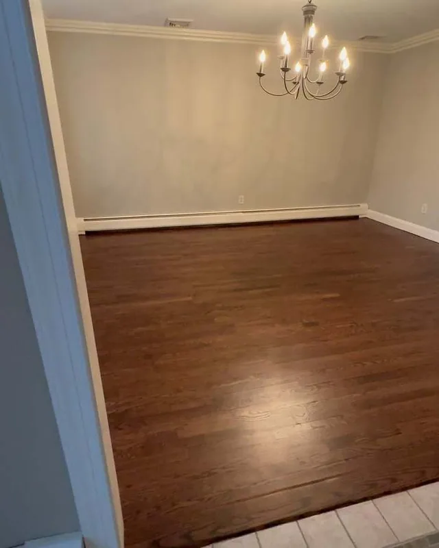 Dark brown stained floor in a dining room with a chandelier