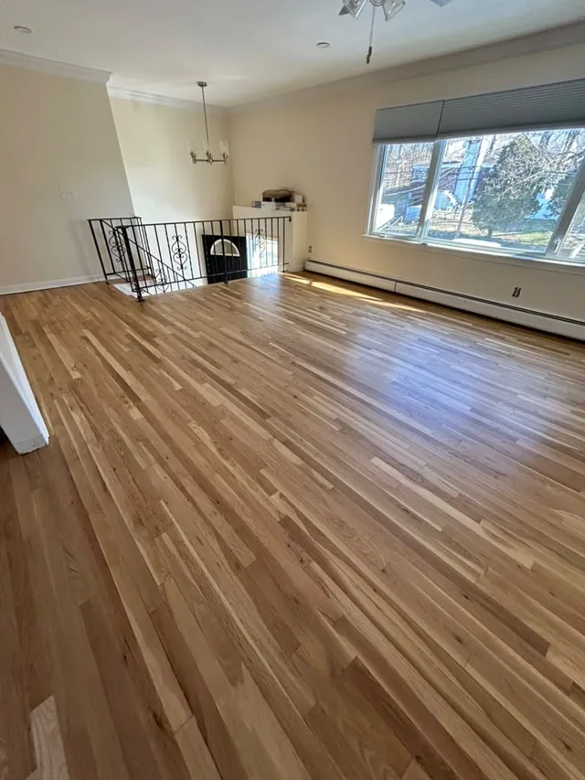 New oak floor in an open room with a wrought-iron stair railing