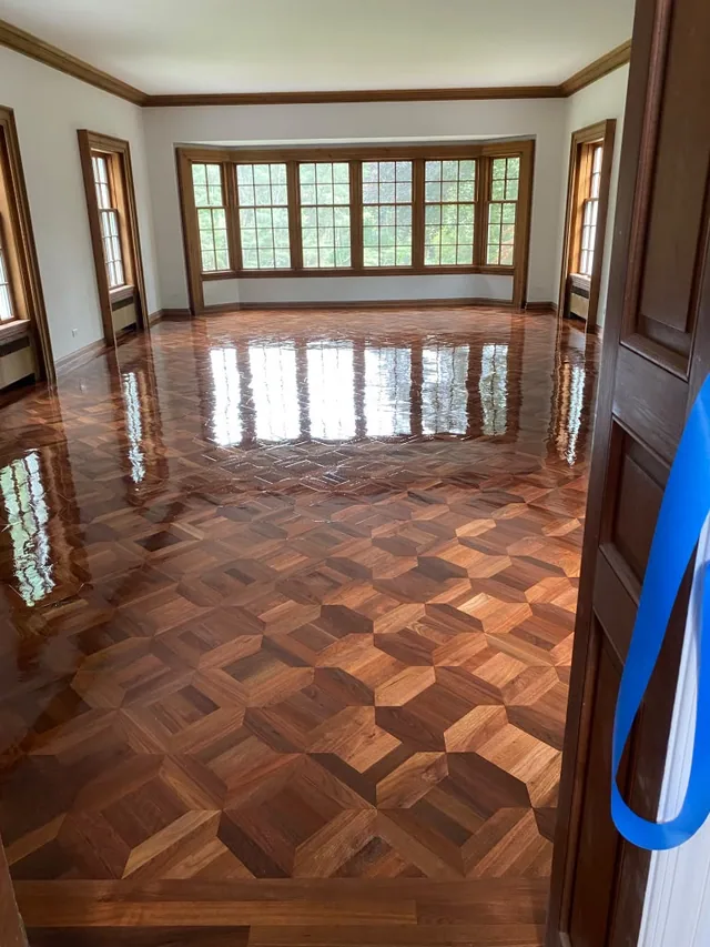 Refinished parquet floor in high gloss under a wall of windows