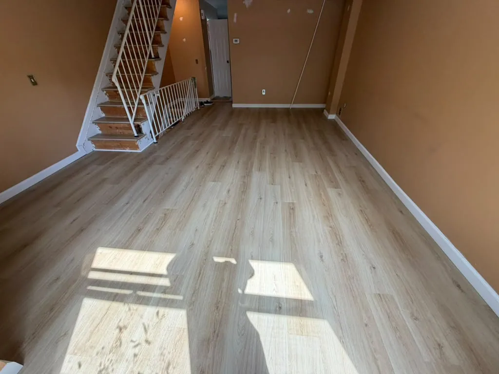 Light plank flooring in a room at the foot of the stairs